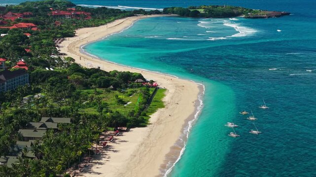 High angle view of a tropical sandy beach with turquoise ocean and luxury resorts