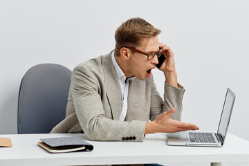 frustrated man using laptop and smartphone in home office casual wear glasses digital detox concept