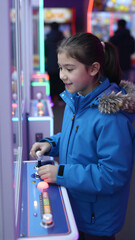 Girl Playing Claw Machine in Arcade