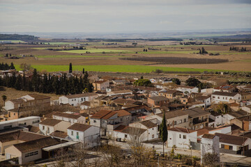 Panoramic view of the Catalan village of Suchs in Lleida, surrounded by farmland and fields. Traditional architecture in a peaceful, rural Mediterranean landscape.  © aitor