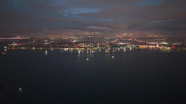 Aerial view of the Harem waterfront on Istanbul's Asian side at night. Highlights the ferry terminal, coastal lights, and the shimmering Bosphorus. UHD.