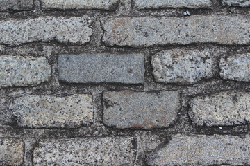 Fototapeta premium Texture of cobblestone. Pattern of sidewalk tiles in the street. Cobblestones close up background.