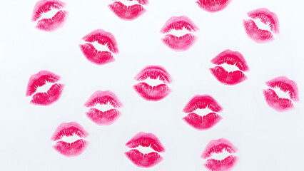 Vibrant pink lipstick kiss marks on white background