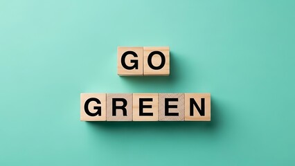 Go Green message spelled out with wooden letter blocks on a solid teal background, environmental sustainability and ecology concept.