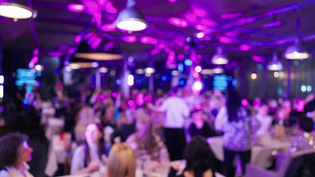Professionals mingle in lively setting, Relaxed professionals socialize amid colorful neon accents at night