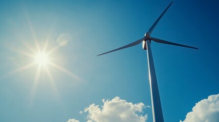 Wind turbine against blue sky with sunlight generating clean energy