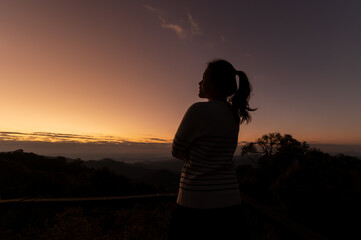 silhouette of asian woman on mountain with beautiful scene on mountain