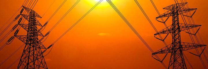 High voltage power lines silhouetted against a radiant sunset