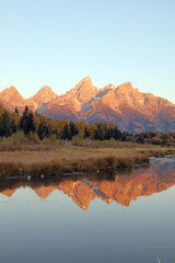 Tetons and their reflections illuminated by dawn light, Grand Teton National Park, Wyoming  USA
