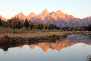 Tetons and their reflections illuminated by early morning light, Grand Teton National Park, Wyoming  USA
