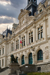 Historic H&ocirc;tel de Ville of Vannes featuring an ornate fa&ccedil;ade, mansard roofs, sculpted stonework, and a prominent central tower, viewed from a foreground garden that enhances its architectural presence