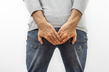 Intestinal problems concept. A man holding his lower back. Diarrhea or symptoms of hemorrhoids.