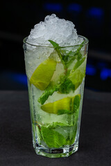 Mojito cocktail with mint and lime served in a tall glass at a bar