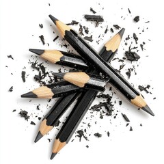 A pile of broken black pencil shavings on a white background