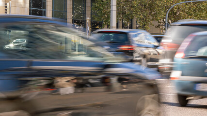 blurred driving cars outdoors on city street, close-up of traffic jam background with motion blur in daylight, concept for modern mobility lifestyle