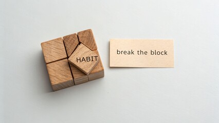 Broken wooden cube labeled Habit representing mindset break