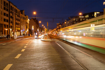 long exposure of urban traffic scene in the blue hour, motion blur with light trail, cars, tram and people at an intersection, Magdeburg, Germany