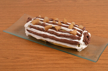 B&ucirc;che de No&euml;l poire et chocolat faite maison dans un plat en gros plan sur un fond en bois