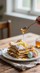 Pancakes with honey drizzle and decorative pastel eggs on rustic table