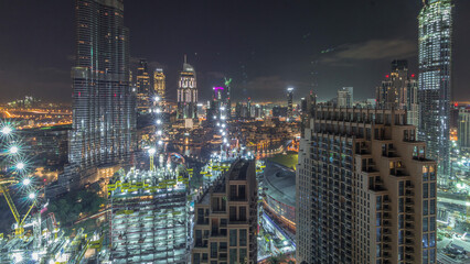 Panoramic skyline view of Dubai downtown with mall, fountains and skyscrapers aerial night timelapse