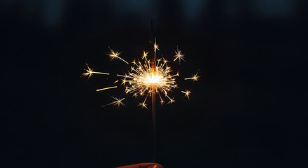 Sparkler Held by Hand Against Dark Background
