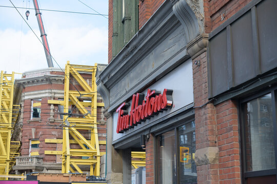 oblique angle view of old building and Tim Hortons shop sign at 441 Queen St W, Toronto
