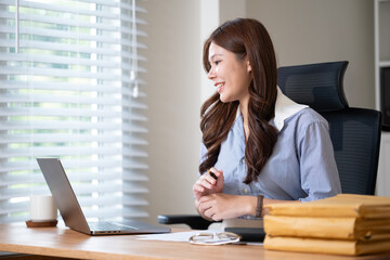 Smiling businesswoman enjoying a virtual meeting while working from home.