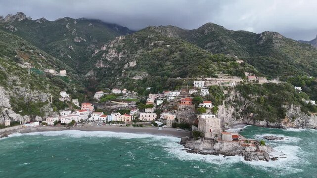 Aerial view of the vibrant Erchie beach with its historic coastal tower, set against the turquoise sea and rocky cliffs, Erchie, Amalfi Coast, Italy.