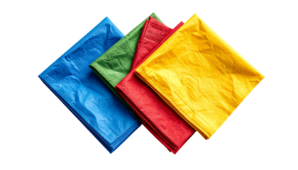 Four colorful, folded cloths of blue, green, red and yellow, neatly stacked, against black