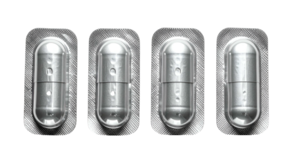 Close-up of four capsules encased in silver blister packaging against a black background