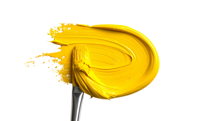 A brush loaded with vibrant yellow paint creating a textured swirl against a black background