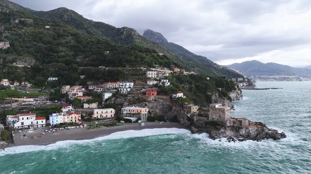 Aerial view of the vibrant Erchie beach with its historic coastal tower, set against the turquoise sea and rocky cliffs, Erchie, Amalfi Coast, Italy.