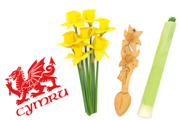 Welsh Cymru red dragon flag, not copyrighted, and Welsh national symbols of daffodils and leeks for St Davids Day, carved daffodil love spoon courtship token of affection and love. 