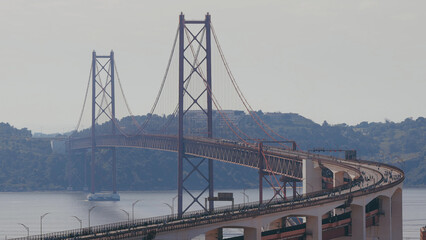 Running Lisbon half marathon crossing the 25 of April bridge over the Tagus river aerial view from above.