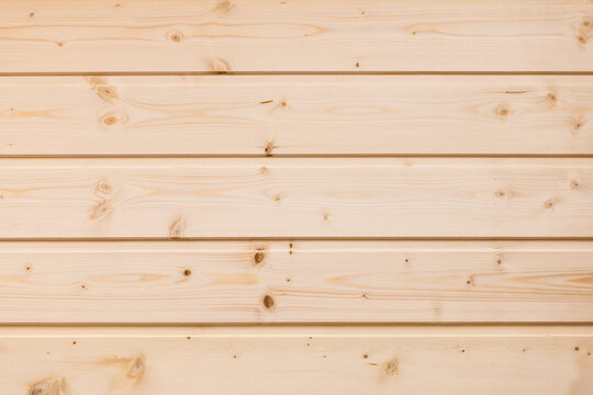 A wall panel of warm, light pine wood planks with natural grain and knots