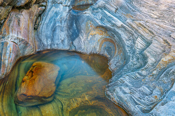A quiet interplay of layered rock and still water, revealing the subtle textures and colors shaped by time, verzasca river near Lavertezzo, Switzerland