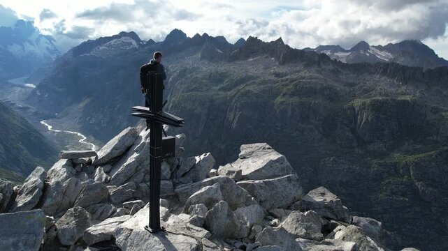 Cinematic Drone Shot of Man Standing on Rocky Mountain Summit in Swiss Alps &ndash; Freedom, Adventure and Epic Alpine Panorama