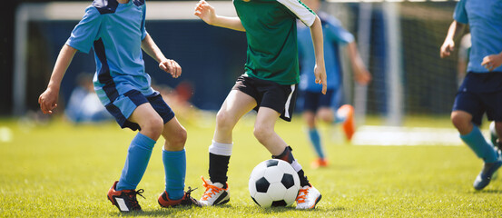 Kids Playing Soccer During Youth Match – Children Competing in Outdoor Football Game on Grass Field © matimix