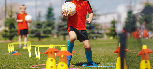 Child Practicing Soccer Dribbling Drill &ndash; Youth Football Agility Training With Cones on Outdoor Field