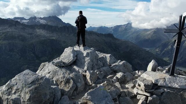 Cinematic Drone Shot of Man Standing on Rocky Mountain Summit in Swiss Alps &ndash; Freedom, Adventure and Epic Alpine Panorama