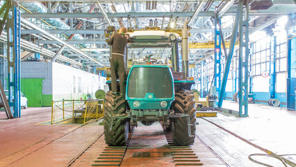 Conveyor assembly stage the body of tractor at big industrial factory timelapse