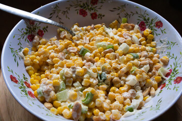 Summer side dish of sweet corn kernels with creamy dressing and nuts