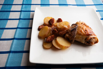 Nutritious homemade dinner of baked chicken and chorizo on square plate