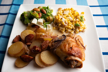 Roasted Chicken Thigh with Pan-Fried Potato Rounds and Spicy Chorizo Slices, Fresh Garden Salad with Feta Cheese Cubes, Whole Almonds, and Green Olives