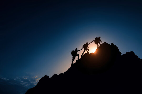 Team members support each other while climbing a mountain during sunset. They hold hands as they reach for the top, demonstrating unity and effort