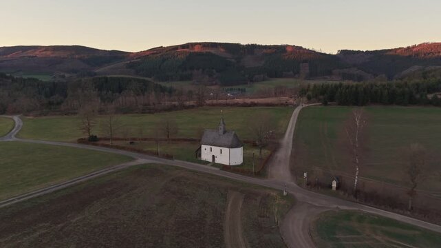 Aerial 4K reveal of the lonely Rochus chapel and its iconic landscape frame at golden hour. Symbol of vision, peace, and natural beauty.