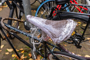 mit Plastikfolie umwickelter Fahrradsattel, Amsterdam, Niederlande