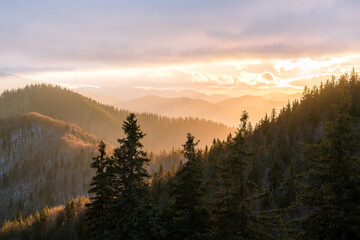 Panoramic mountain landscape with hazy ridges, sunset sky