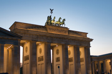 Brandenburg Gate illuminated at twilight - The iconic Brandenburg Gate in Berlin, a symbol of peace and unity, beautifully illuminated against the twilight sky at Pariser Platz, Germany.