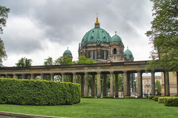 Berlin Cathedral View from Lustgarten Colonnade - The majestic Berlin Cathedral (Berliner Dom) viewed from the Lustgarten park, framed by a classical colonnade and manicured green hedges. © jmag.foto